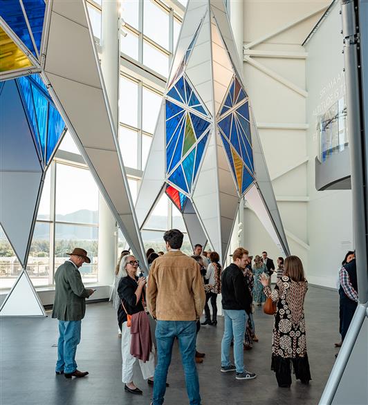 People standing underneath some art fixtures