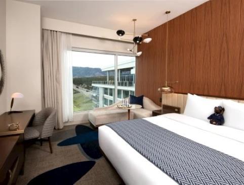 A room with a stuffed bear on the bed
