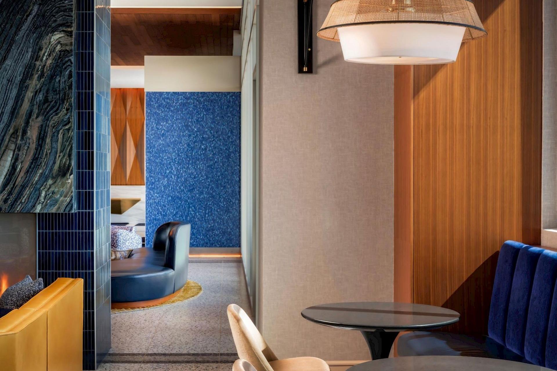 Modern seating area at Hotel Polaris with blue banquette seating, warm wood finishes, and contemporary lighting.
