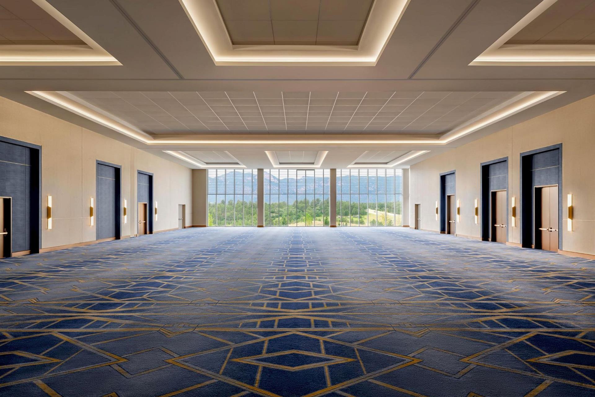 Spacious ballroom at Hotel Polaris featuring floor-to-ceiling windows, modern lighting, and flexible event space with panoramic views of the Rocky Mountains.